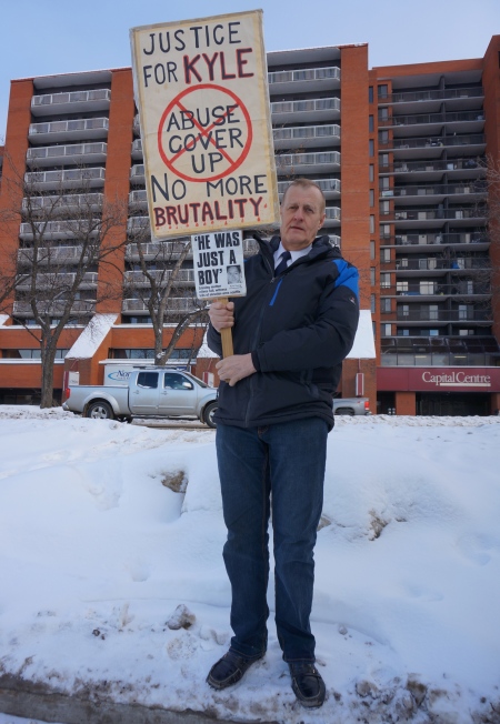 Rob Wells with Protest Sign [photo taken by author on 6 January 2014]